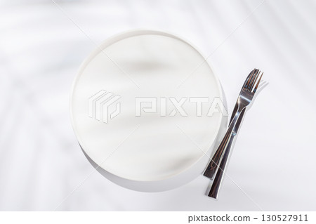 Empty plate on a white background with leaf shadows, perfect food mockup Empty plate on a white background with leaf shadows, perfect food mockup 130527911