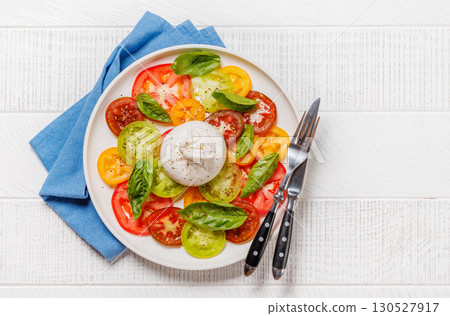 Fresh burrata served on slices of colorful tomatoes Fresh burrata served on slices of colorful tomatoes 130527917