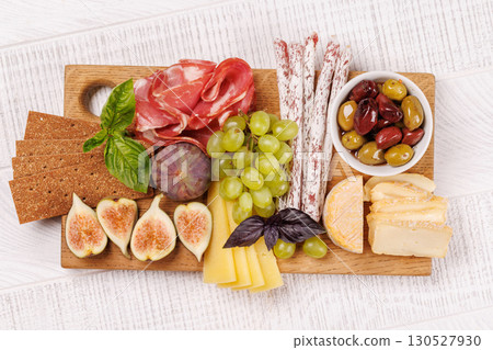 Antipasto platter with prosciutto, cheese, olives, salami, figs, grapes, and crackers 130527930