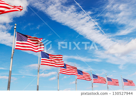 Rows of American flags waving against a sunny sky 130527944