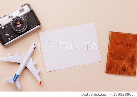 Travel-themed flat lay with blank photo card, camera, toy airplane, and passport Travel-themed flat lay with blank photo card, camera, toy airplane, and passport 130528003