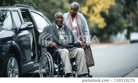 Caregiver assisting senior african american man in wheelchair getting out of an accessible car 130528279