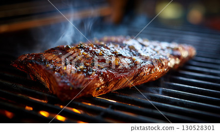 Delicious skirt steak grilling on a hot barbecue grill, smoke rising from the meat Delicious skirt steak grilling on a hot barbecue grill, smoke rising from the meat 130528301
