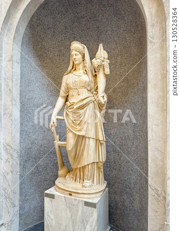 VATICAN CITY, ROME, ITALY - AUGUST 02, 2025 Classical marble sculpture depicts Fortuna, the Roman goddess of luck, chance, and fate, holding a cornucopia overflowing with fruits and a ship's rudder VATICAN CITY, ROME, ITALY - AUGUST 02, 2025 Classical marble sculpture depicts Fortuna, the Roman goddess of luck, chance, and fate, holding a cornucopia overflowing with fruits and a ship's rudder 130528364