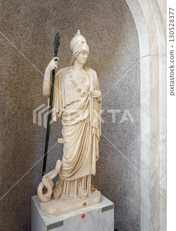 VATICAN CITY, ROME, ITALY - AUGUST 02, 2025 Classical marble statue of Athena Giustiniani. The goddess of wisdom and war holds a spear in her hand and is accompanied by the serpent Erichthonius 130528377