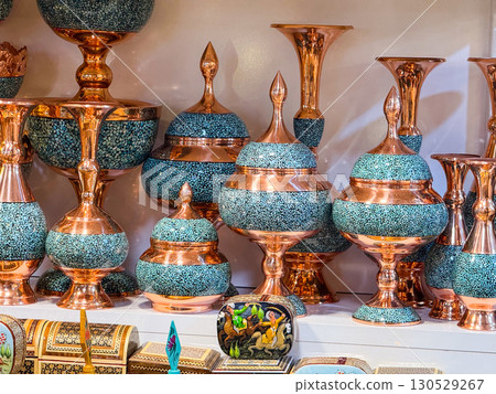 Copper vessels with turquoise stone inlay displayed in a shop. Traditional craftsmanship, heritage art, and decorative objects representing cultural artisan trade. 130529267