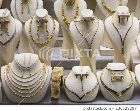 Golden necklace and earrings in a jewelry store. Luxury, wealth, and decorative fashion accessories. Golden necklace and earrings in a jewelry store. Luxury, wealth, and decorative fashion accessories. 130529297