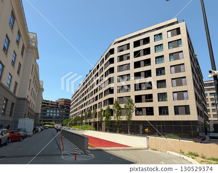 Modern residential apartment block with balconies and windows in urban street view. Architecture, real estate, and city development symbolizing housing, lifestyle and investment. 130529374