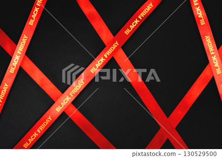 Black Friday sale background with red satin ribbons and diagonal layout Elegant red ribbon composition on dark background for holiday promotions 130529500