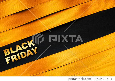 Sale background with yellow satin ribbons and bold black contrast Stylish yellow satin ribbons on black background with Black Friday text 130529504