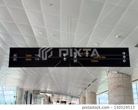 Airport directional sign with gates information in terminal hall. Travel navigation, passenger guidance, and public facility signage for aviation infrastructure. Airport directional sign with gates information in terminal hall. Travel navigation, passenger guidance, and public facility signage for aviation infrastructure. 130529513