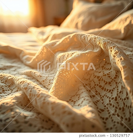 Bedroom with textured bedding and ambient lighting. 130529757