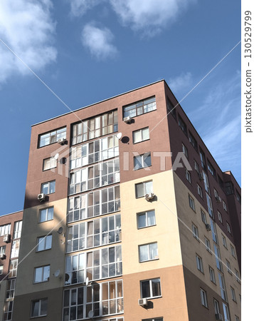 Modern apartment building with a beige facade and multi family structure. Residential property Modern apartment building with a beige facade and multi family structure. Residential property 130529799