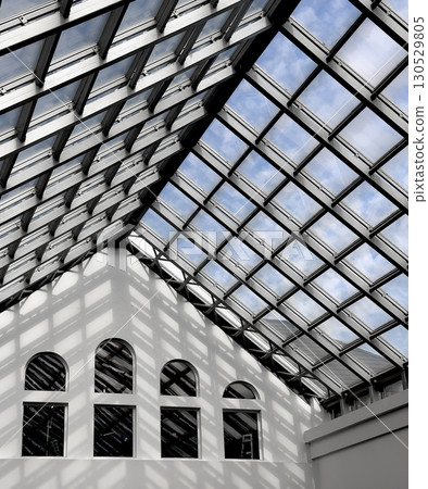 Modern architectural interior with a large geometric glass ceiling that lets sunlight stream in, Modern architectural interior with a large geometric glass ceiling that lets sunlight stream in, 130529805
