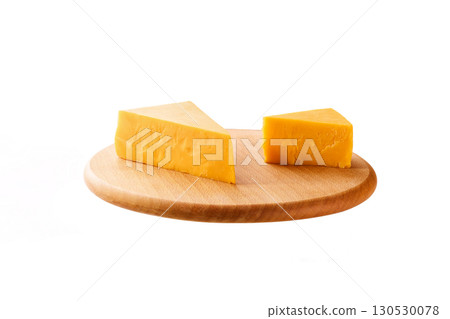 piece of cheddar cheese on a cutting board isolated on a white background. 130530078