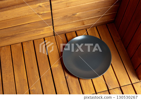 Empty black plate on natural wooden background. 130530267