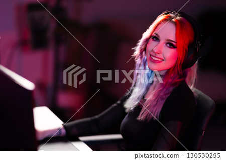 Young female gamer enjoying e-sports in a vibrant gaming setup Young female gamer enjoying e-sports in a vibrant gaming setup 130530295