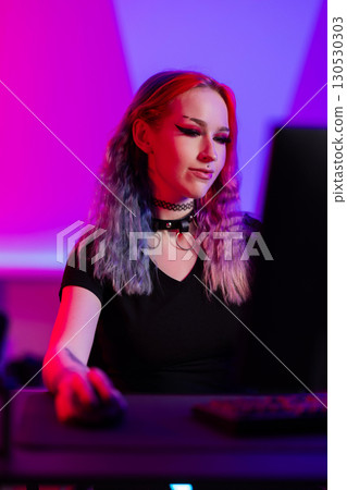 Young woman gaming in vibrant pink and blue ambient lighting setting Young woman gaming in vibrant pink and blue ambient lighting setting 130530303