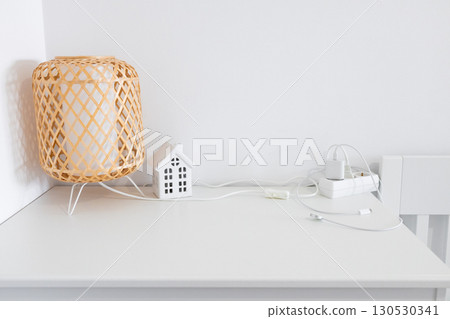 Decorative lamp and house figurine on minimalist white surface with power cables Decorative lamp and house figurine on minimalist white surface with power cables 130530341