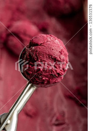 Scoop of vibrant berry sorbet in metal ice cream scooper, close-up, natural texture Scoop of vibrant berry sorbet in metal ice cream scooper, close-up, natural texture 130531576