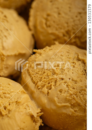 Creamy caramel ice cream scoops in rich golden tones, perfect for dessert advertising Creamy caramel ice cream scoops in rich golden tones, perfect for dessert advertising 130531579