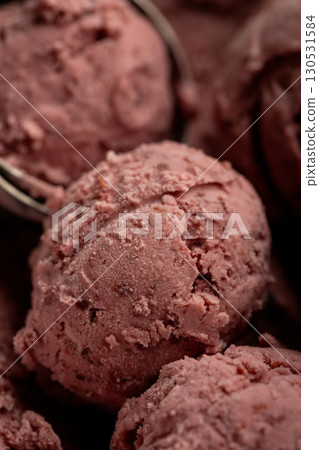 Creamy raspberry ice cream scoops in close-up, rich texture and vibrant pink color 130531584