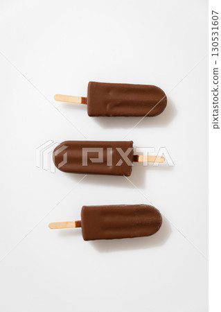 Chocolate ice cream popsicles on white background. Minimalist summer dessert concept Chocolate ice cream popsicles on white background. Minimalist summer dessert concept 130531607