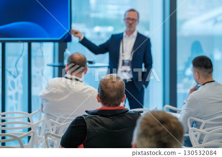 Business presentation with audience in a conference setting next to large windows 130532084