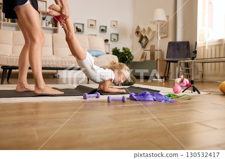 Child Having Fun During Home Exercise Assisted By Parent on Yoga Mat Child Having Fun During Home Exercise Assisted By Parent on Yoga Mat 130532417
