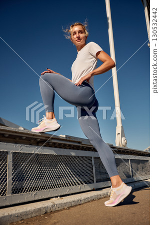Woman in activewear stepping outside on a sunny day for fitness activity Woman in activewear stepping outside on a sunny day for fitness activity 130532442