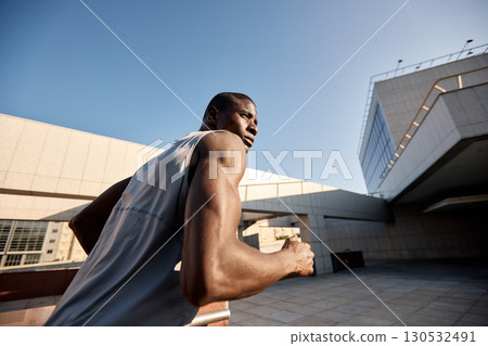 Urban runner in action captured on a sunny day outdoors 130532491