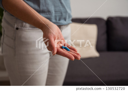 Woman holding blue pills in hand. Health care, dietary supplements, treatment of depression and diseases Woman holding blue pills in hand. Health care, dietary supplements, treatment of depression and diseases 130532720