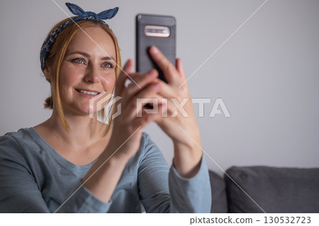 Middle aged millennial woman holding smartphone, social media, communication and modern technology Middle aged millennial woman holding smartphone, social media, communication and modern technology 130532723