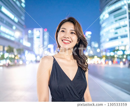 晚上，一位年輕女子站在繁忙的市中心 130533359