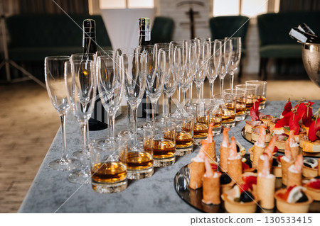 Elegant catering setup with gourmet canapes and whiskey in glasses for a corporate event Elegant catering setup with gourmet canapes and whiskey in glasses for a corporate event 130533415