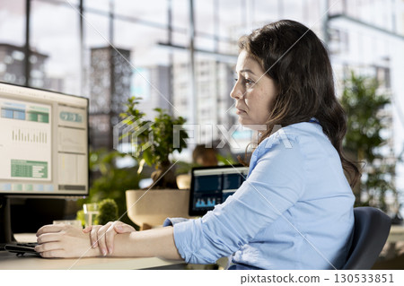 Disconnected female employee dealing with depersonalization and being detached from reality, losing focus at her desk. General manager suffering from a dissociation disorder, is a workaholic. 130533851