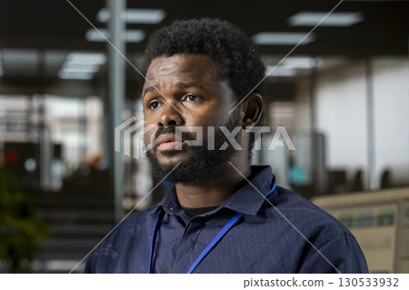 Confident male manager multitasking at the office to handle administrative tasks on the workstation, business tasks. Young man reviewing documents and meeting project deadlines. 130533932