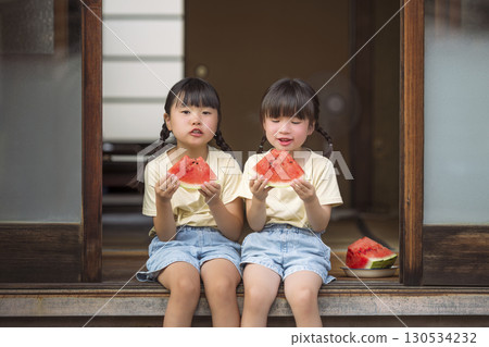 A girl eating watermelon on the veranda A girl eating watermelon on the veranda 130534232