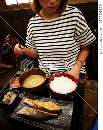 A Chinese woman eating a large portion of rice in the morning 130534320