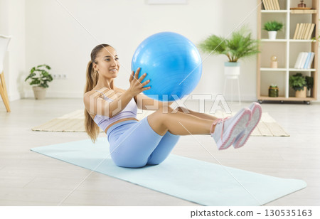 Woman Exercising At Home With Fitball For Abs Workout Woman Exercising At Home With Fitball For Abs Workout 130535163