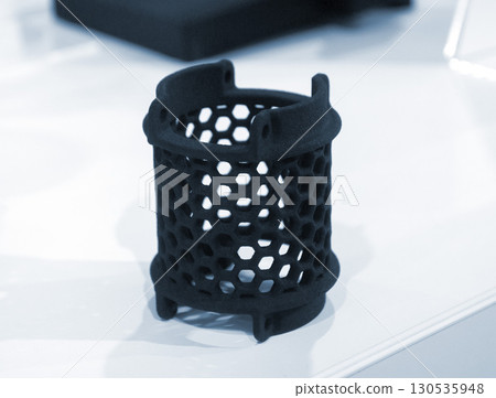 Object printed on 3D printer from molten plastic powder close-up. Model printed on 3D printer from melted polyamide powder. New modern additive 3D printing technology. Multi Jet Fusion MJF technology Object printed on 3D printer from molten plastic powder close-up. Model printed on 3D printer from melted polyamide powder. New modern additive 3D printing technology. Multi Jet Fusion MJF technology 130535948