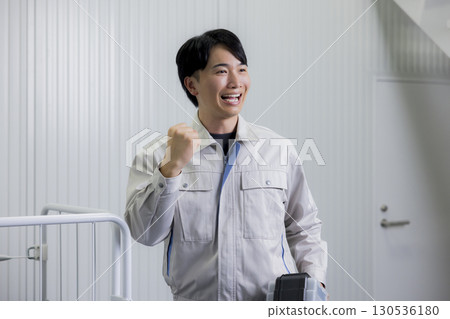 一名身穿工作服的男子推著推車 一名身穿工作服的男子推著推車 130536180