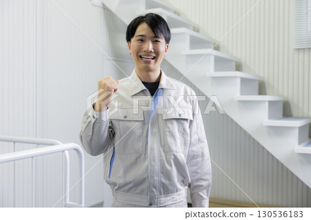 一名身穿工作服的男子推著推車 一名身穿工作服的男子推著推車 130536183