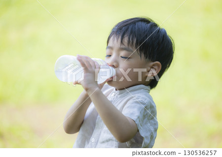 Child drinking a plastic bottle drink 130536257
