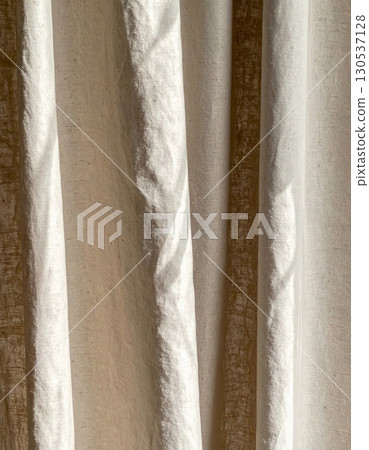 Beige Linen Fabric Texture with Gentle Folds in a Soft Natural Light Creating an Abstract Background 130537128