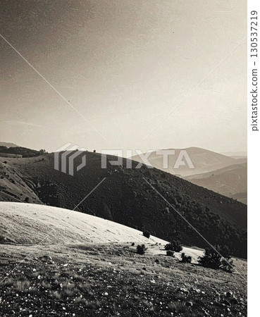 Sepia Tone Mountain Landscape With Rolling Hills Under a Partly Cloudy Sky in Countryside 130537219
