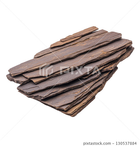 A stack of layered, flat, brown slate stones is arranged neatly, showcasing their natural texture and earthy tones. These stones are often used landscaping and construction for their durability 130537884