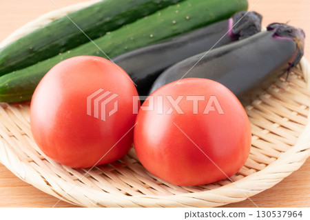 Close-up of tomatoes, eggplants and cucumbers (summer vegetables) on a bamboo colander 130537964