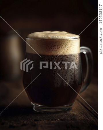 Mug of dark beer with creamy foam sits under moody lighting, evoking comforting and relaxed mood in pub setting 130538147