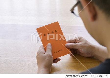 一名男子正在看他的退休金簿 130538364